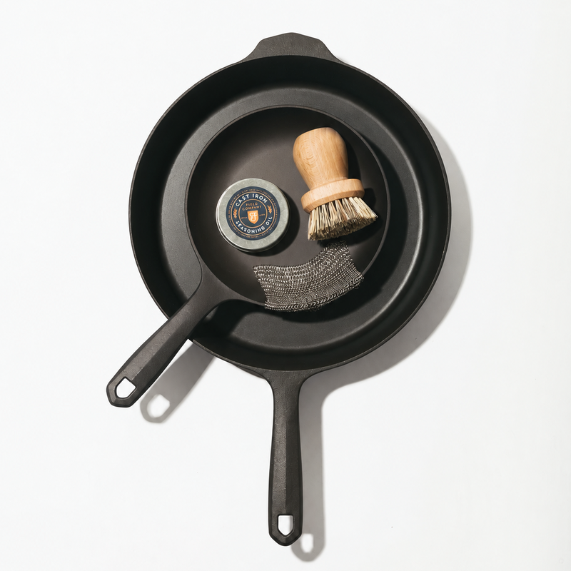 Overhead of the Daily Duo Set: two Field Skillets with pot brush, chain mail scrubber, and seasoning oil tin