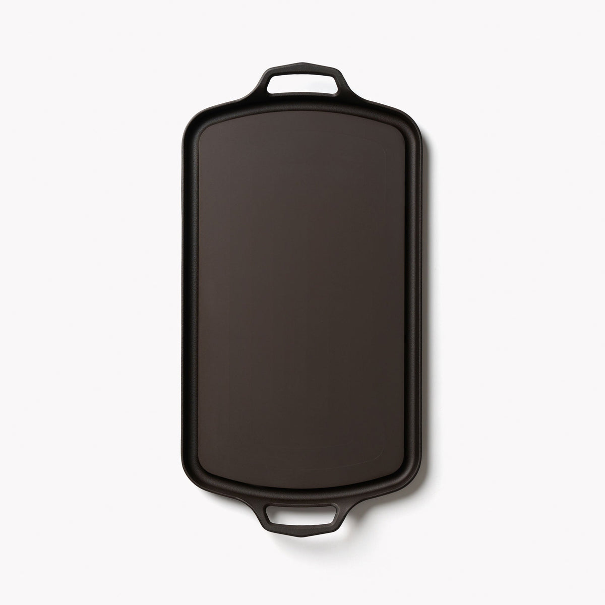 Field long cast iron griddle from above, rectangular with a loop handle at each end