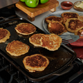 Pancakes cooking on a Field long cast iron griddle set over two stovetop burners thumbnail