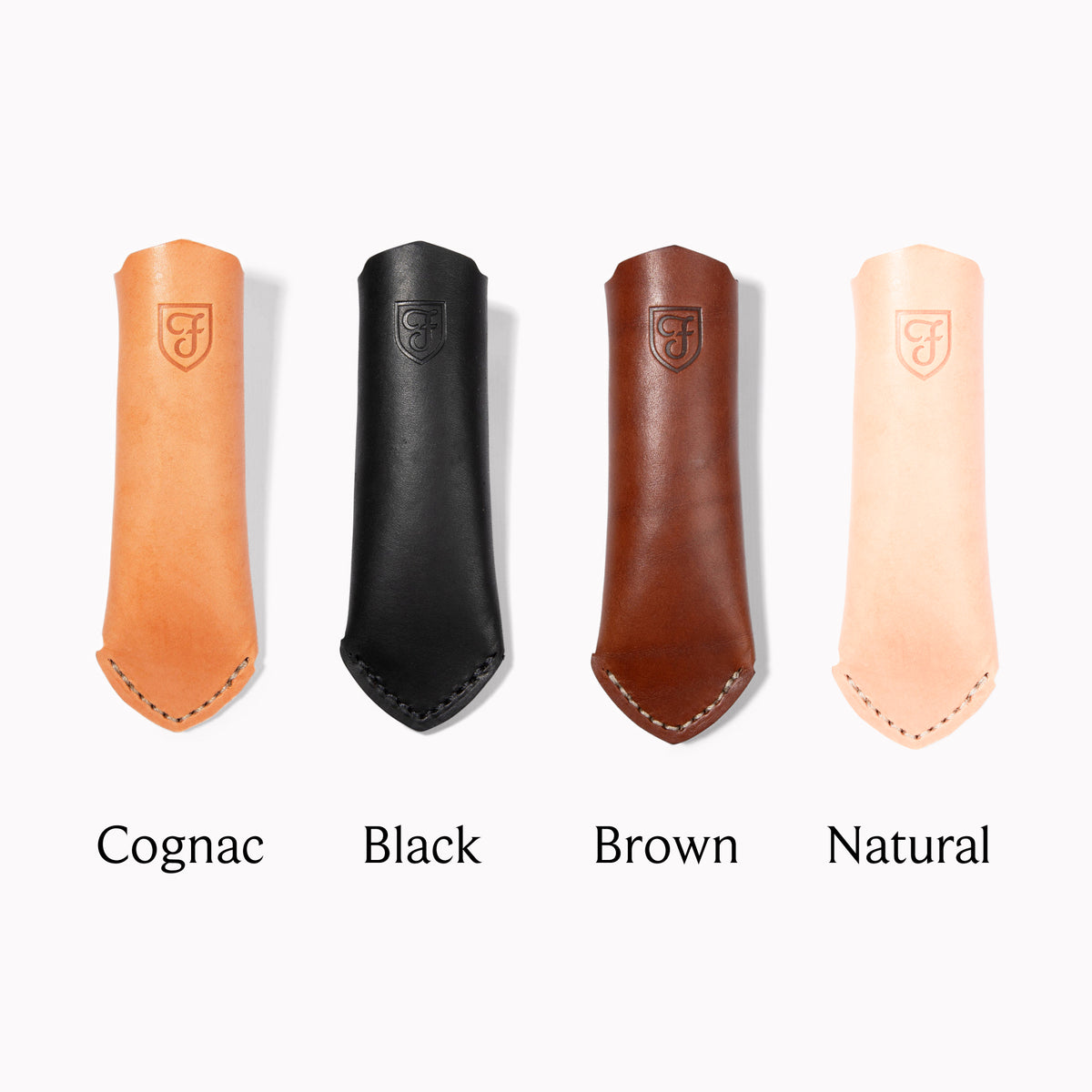 Four Field leather handle covers labeled Cognac, Black, Brown and Natural, laid in a row