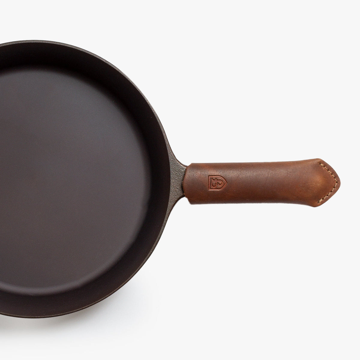Brown Field leather handle cover fitted on a cast iron skillet handle, seen from above