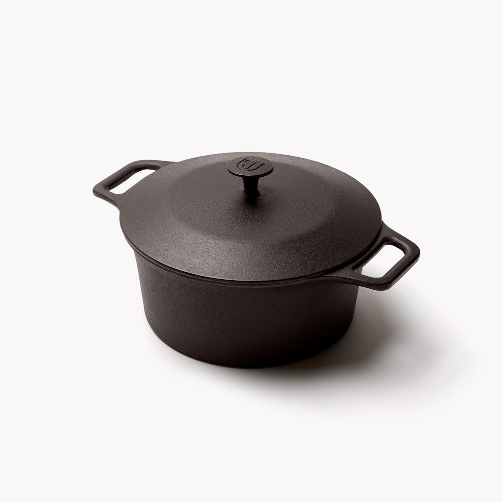 Field cast iron Dutch oven with its lid on, seen at an angle with both loop handles