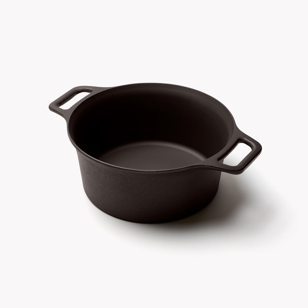 Field cast iron Dutch oven without its lid, angled to show the interior and loop handles