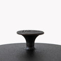 Close-up of the knob on a Field Dutch oven lid, shield medallion on top thumbnail