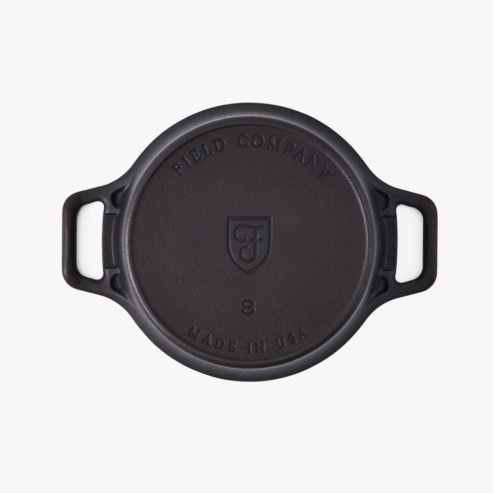Underside of a cast iron Dutch oven stamped Field Company, Made in USA and the size 8
