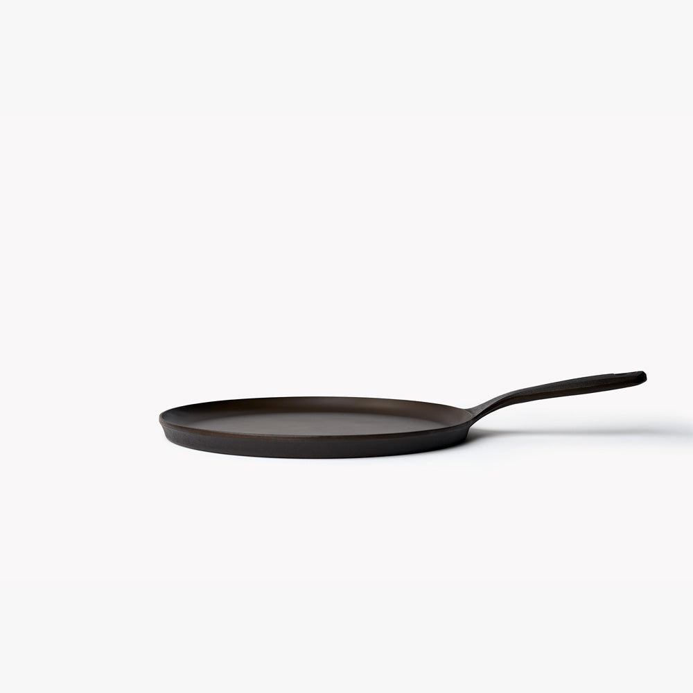 Side profile of a Field round cast iron griddle, showing its low flat rim